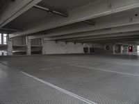 a dark parking garage filled with concrete pillars and ramps and walls and lots of other empty space