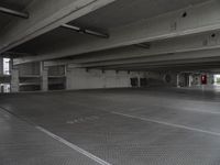 a dark parking garage filled with concrete pillars and ramps and walls and lots of other empty space