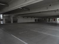 a dark parking garage filled with concrete pillars and ramps and walls and lots of other empty space