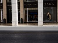the entrance to a store that is on the street corner with some signs in front of it