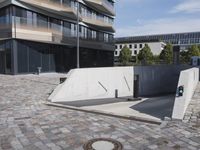 a brick building with glass windows and sidewalk leading to it and a black fire hydrant