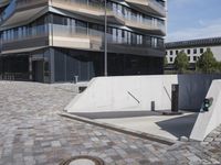 a brick building with glass windows and sidewalk leading to it and a black fire hydrant