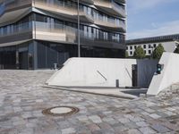 a brick building with glass windows and sidewalk leading to it and a black fire hydrant