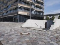 a brick building with glass windows and sidewalk leading to it and a black fire hydrant