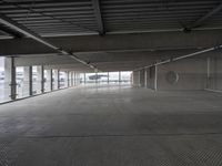 a large empty parking space with lots of windows and grates on the ground inside a building