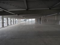 a large empty parking space with lots of windows and grates on the ground inside a building