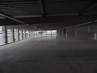 a large empty parking space with lots of windows and grates on the ground inside a building