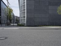 a concrete building is seen near a city street intersection in front of an asphalt parking lot