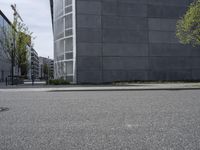 a concrete building is seen near a city street intersection in front of an asphalt parking lot