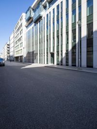 the building has several floors and has glass walls along the side of it, there are windows