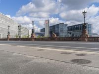 a city street with statues and lamp post on one side and two building on the other