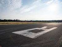 a view from an airport runway with a white line that runs from it to the right of the airplane