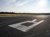 a view from an airport runway with a white line that runs from it to the right of the airplane