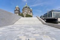 a shadow on the ground with a building behind it and buildings behind it with steeple steps going up to them