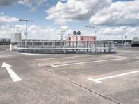 an airport with parking spaces and buildings with signs on each side of the road and arrows pointing right