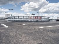 an airport with parking spaces and buildings with signs on each side of the road and arrows pointing right