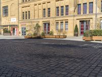 a city square has some umbrellas on the side of it and people are sitting on benches