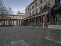 stone path in courtyard with pillars in the building beside it and sign that reads musees du crec between columns