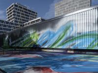 a group of people walk by some colorful art on a wall near tall buildings with metal poles