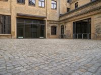 an open courtyard with bikes in the background on a sunny day at a brick building