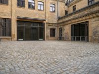 an open courtyard with bikes in the background on a sunny day at a brick building