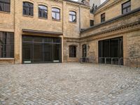 an open courtyard with bikes in the background on a sunny day at a brick building