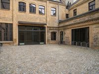 an open courtyard with bikes in the background on a sunny day at a brick building