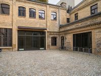 an open courtyard with bikes in the background on a sunny day at a brick building