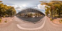 fish - eye view of a city street with trees and a bridge, and in the middle there is a street