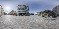 a 360 - view of a circular driveway in front of a building, cars and a bike