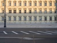 the crosswalk has painted markings on it, with the large buildings in the background