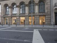 a street corner with the intersection of a cross walk and building with multiple windows on each side