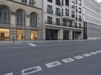 a street corner with the intersection of a cross walk and building with multiple windows on each side