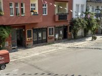 an image of city street that looks really narrow and empty looking outside from a balcony