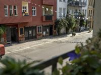 an image of city street that looks really narrow and empty looking outside from a balcony