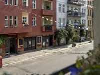 an image of city street that looks really narrow and empty looking outside from a balcony