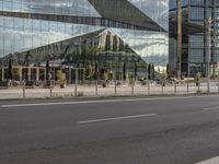 a city street that has a glass building near by it's reflection in the windows