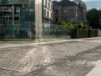 a city street with lots of glass walls and a sidewalk, trees and a walkway