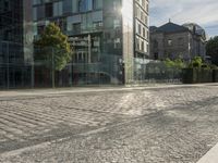 a city street with lots of glass walls and a sidewalk, trees and a walkway