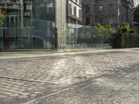 a city street with lots of glass walls and a sidewalk, trees and a walkway