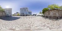 a 360 - view photograph of the circular city street that is in front of some large buildings