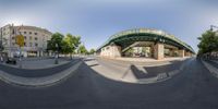 fish eye image of a city street in a panorama style with a pedestrian bridge and buildings