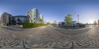 a fish eye lens panoramic picture of buildings on a city street near water