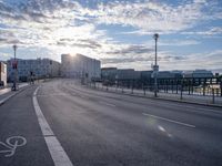 a city street with the sun in the background and bike lane marking in the middle