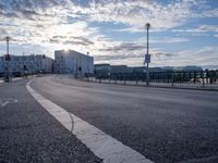 a city street with the sun in the background and bike lane marking in the middle