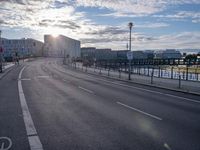 a city street with the sun in the background and bike lane marking in the middle