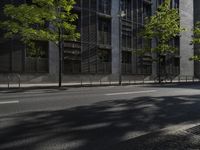 a city street with trees in front of some tall buildings and an orange traffic light