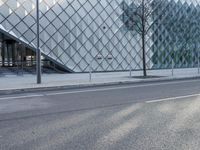 a building with large glass blocks and a tree in front of it on the side of the street