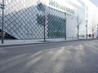 a building with large glass blocks and a tree in front of it on the side of the street