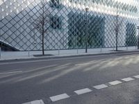 a building with large glass blocks and a tree in front of it on the side of the street